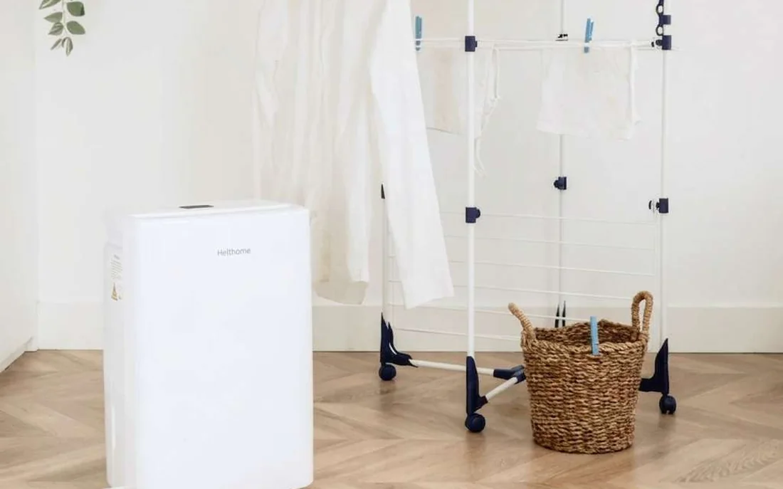 Helthome luchtontvochtiger met wasdroogfunctie naast een wasrek met drogend wasgoed