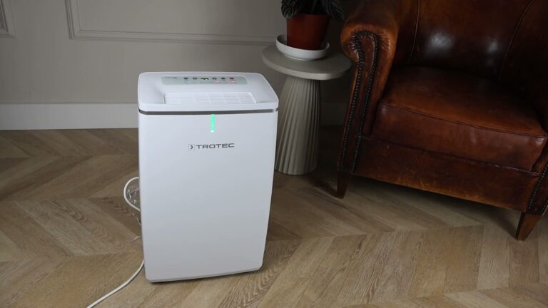 Trotec TTK 72 E luchtontvochtiger met groen lampje naast een leren fauteuil